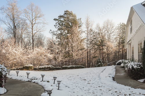 Snow covering the lawn by a house on a winter morning
