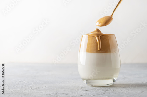 Korean drink Dalgona coffee in glass with milk with and instant coffee on white. Copy space. photo