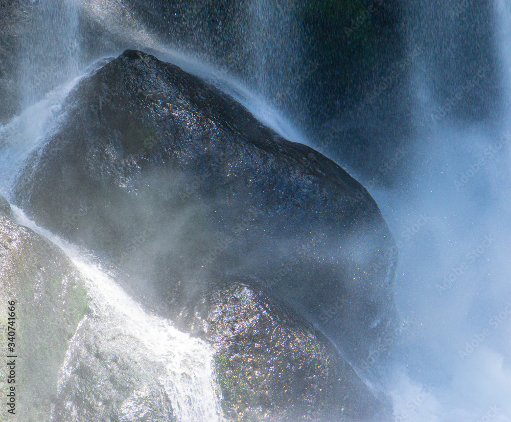 misty water hitting the rocks in a waterfall 

