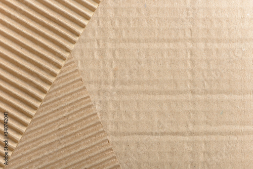Carton or cardboard packing material. Texture of corrugated paper sheets made from cellulose. Supplies for creating boxes and packaging. Pasteboard background. Natural brown cardboard surface.