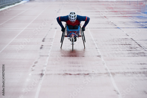 Fotografie Determined wheelchair racer in sportswear and helmet reaching finish line