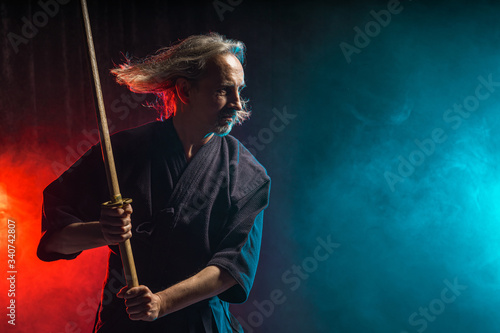 confident caucasian kendo warrior in traditional outfit use bamboo sword shinai for fighting, katana, samurai concept
