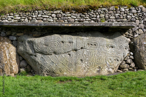 The beautifully decorated kerbstone 52 at the rear of Newgrange megalithic passage tomb in the Boyne Valley Ireland. The elaborately carved stone is directly opposite kerbstone 1 at the front entrance photo