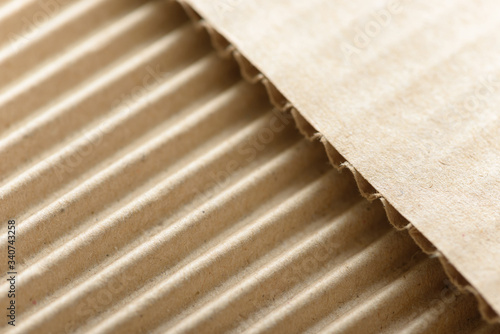 Carton or cardboard packing material. Texture of corrugated paper sheets made from cellulose. Supplies for creating boxes and packaging. Pasteboard background. Natural brown cardboard surface.