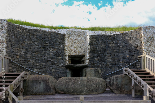 The entrance to Newgrange megalithic passage tomb in the Boyne Valley Meath Ireland, with the famous winter solstice roof box above the doorway and the elaborately decorated front kerb stone.