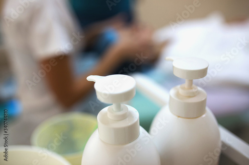 two antiseptic bottles in the foreground, nurse on background. Stop coronavirus COVID-19 concept © skvalval