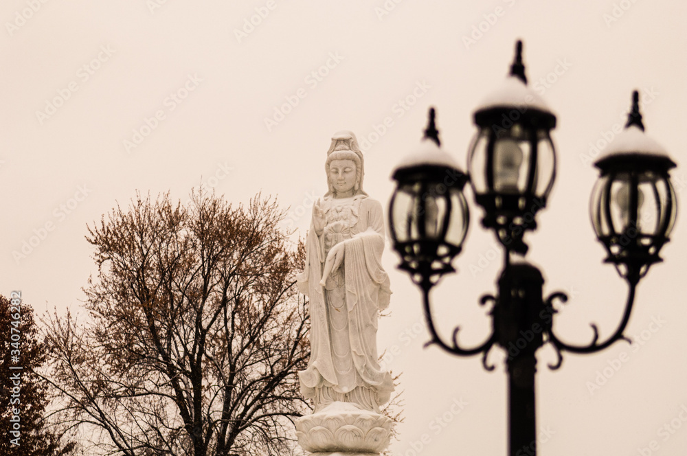Obraz premium Buddhist Statue In Winter By Old Streetlamp, Black and White