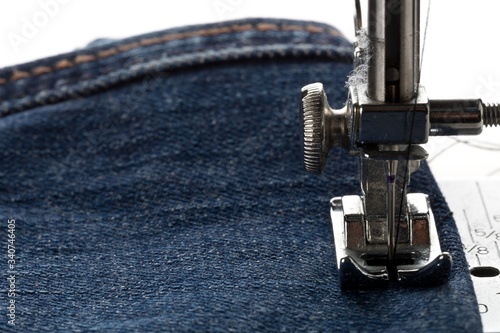 Valokuva Blue jeans denim sewed on sewing machine close up - jeans fashion mending or rep