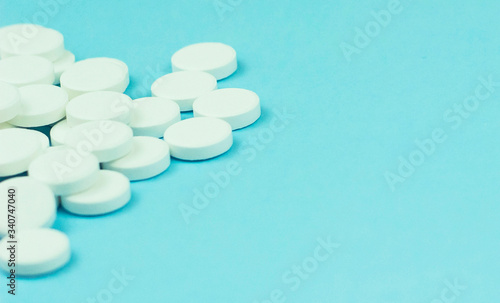 Close-up of many white pills on blue background