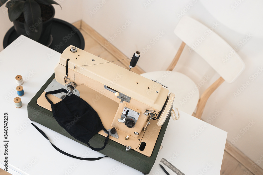 Beige sewing machine the process of sewing a protective medical mask at home is handmade