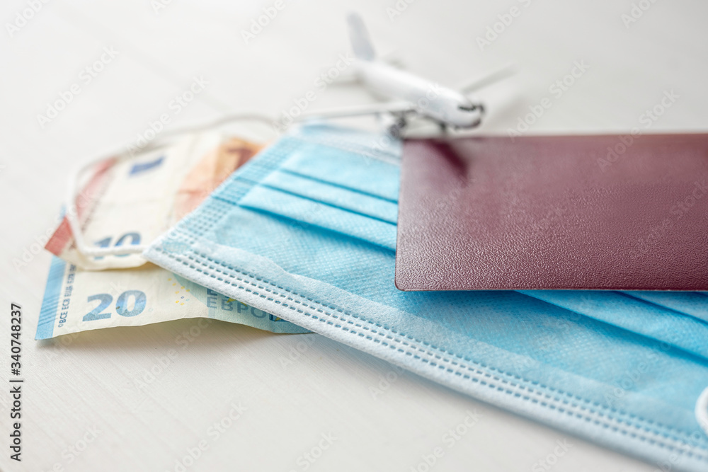 covid 19 holiday fligh travel ban concept detail of face protection mask and passport covid 19 holiday fligh travel ban concept detail of face protection mask and passport