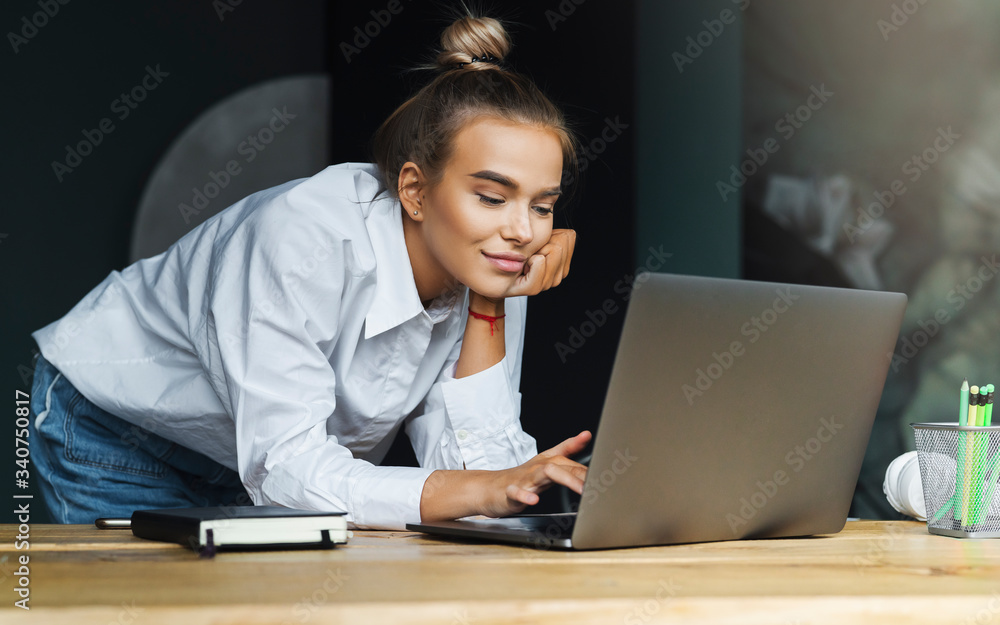 Student preparing for seminar, writing notes in copybook, searching for information online. Female working Student preparing for seminar, writing notes in copybook, searching for information online. Female working