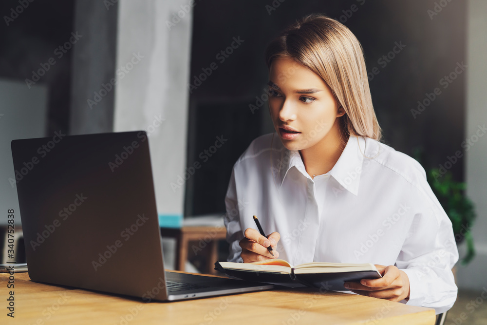 Student studying remotely at home. Young lady sitting in front of laptop, watching at screen and smiling. Isolated Student studying remotely at home. Young lady sitting in front of laptop, watching at screen and smiling. Isolated