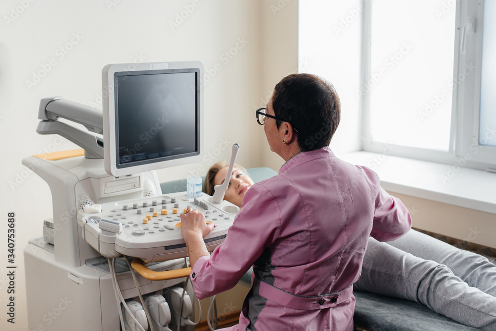 A pregnant girl gets an ultrasound of her abdomen at the clinic. Medical examination