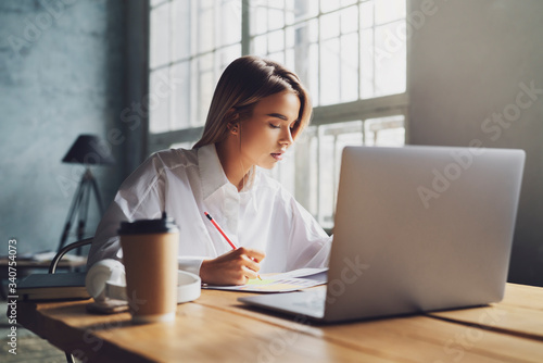 Quadro em tela Girl sitting concentrated at laptop and studying remotely