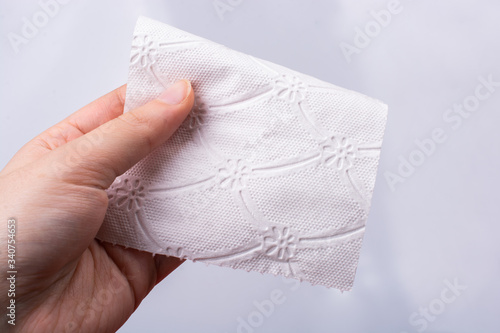 Female hand holding a pece of toilet paper in her hands photo