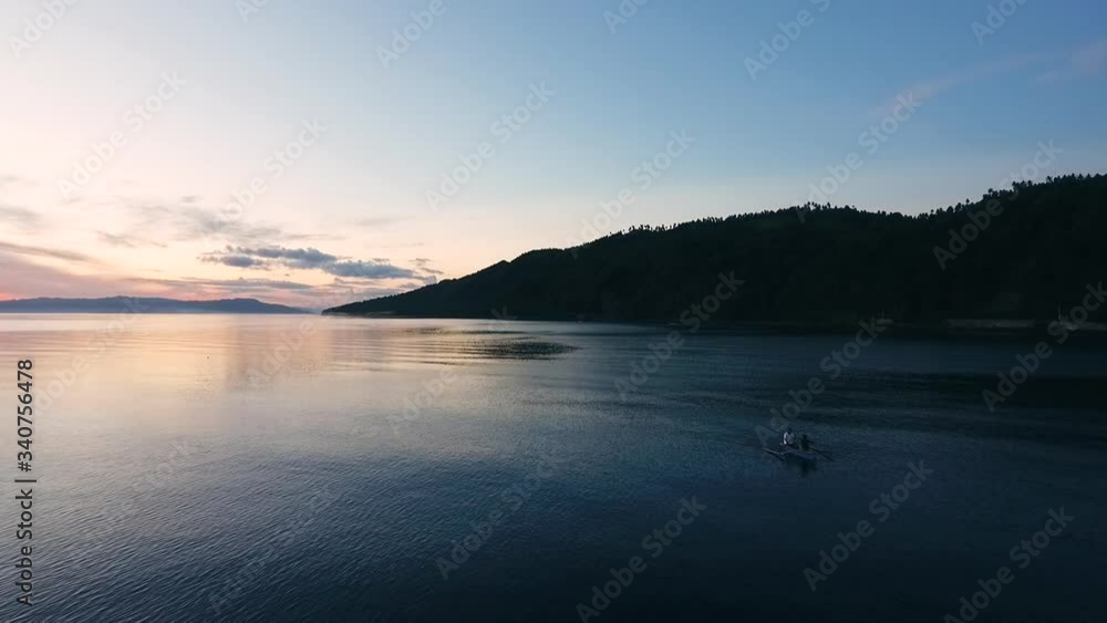 Drone flies towards an island. Calm waters and beautiful sunset view. Drone flies towards an island. Calm waters and beautiful sunset view.