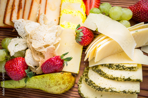 Cheese plate with various cheese, strawberries