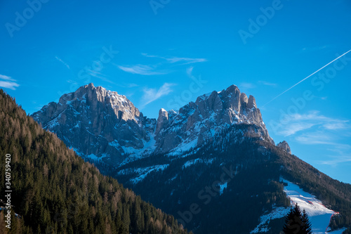 View of coniferous forest and mountains. Sunny winter day. Vigo di Fassa, a commune in Trentino at the northern Italia. Val di Fassa, Dolomiti