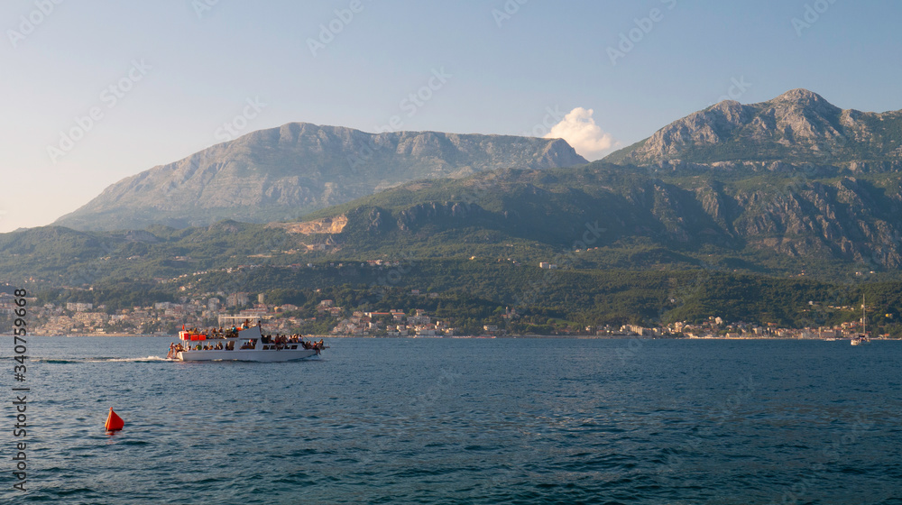 Fototapeta premium Taxi boat with tourists sailing through Kotor Bay, Montenegro, Europe, August 6, 2019 
