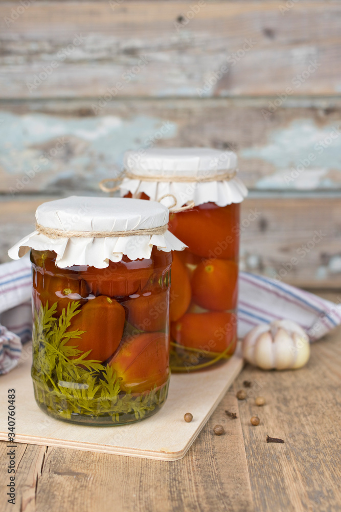 canned tomatoes in jar on the wooden table. canned tomatoes in jar on the wooden table.