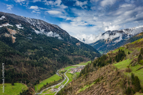 Aerial view of valley with green slopes of the mountains of Italy, Trentino, The trees tumbled down by a wind, huge clouds over a valley, green meadows, Dolomites on background, cloudy weather