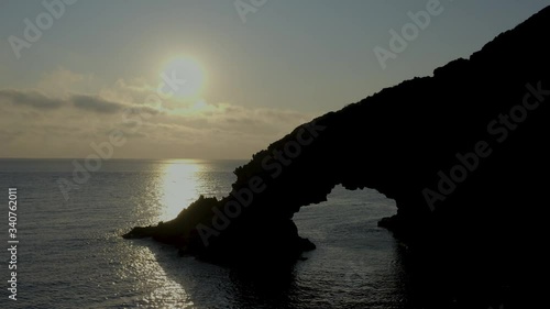 Arco dell'Elefante in Pantelleria Sicily during sunrise. Rock formation of a faraglione whose shape resembles an elephant with its trunk immersed in the water to form the arch.
