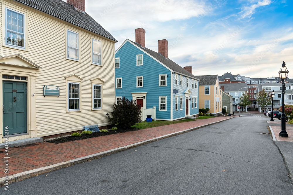 Street lined with traditional pastel coloured New England detached houses at sunset. Portsmouth, NH, USA.