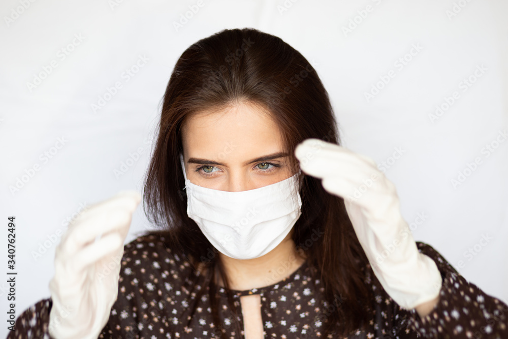 portrait of beautiful young woman wearing cotton white mask and medical/surgical gloves on white background. portrait of beautiful young woman wearing cotton white mask and medical/surgical gloves on white background.