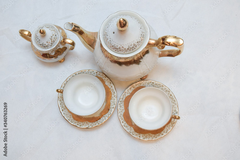 Mock up / design set of elegant and traditional teapot colorful white blue gold coffee cup & Tea cup on cup's plate beside the hot tea pot , design/ drink-ware isolated on white background Mock up / design set of elegant and traditional teapot colorful white blue gold coffee cup & Tea cup on cup's plate beside the hot tea pot , design/ drink-ware isolated on white background