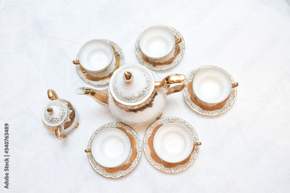 Mock up / design set of elegant and traditional teapot colorful white blue gold coffee cup & Tea cup on cup's plate beside the hot tea pot , design/ drink-ware isolated on white background Mock up / design set of elegant and traditional teapot colorful white blue gold coffee cup & Tea cup on cup's plate beside the hot tea pot , design/ drink-ware isolated on white background