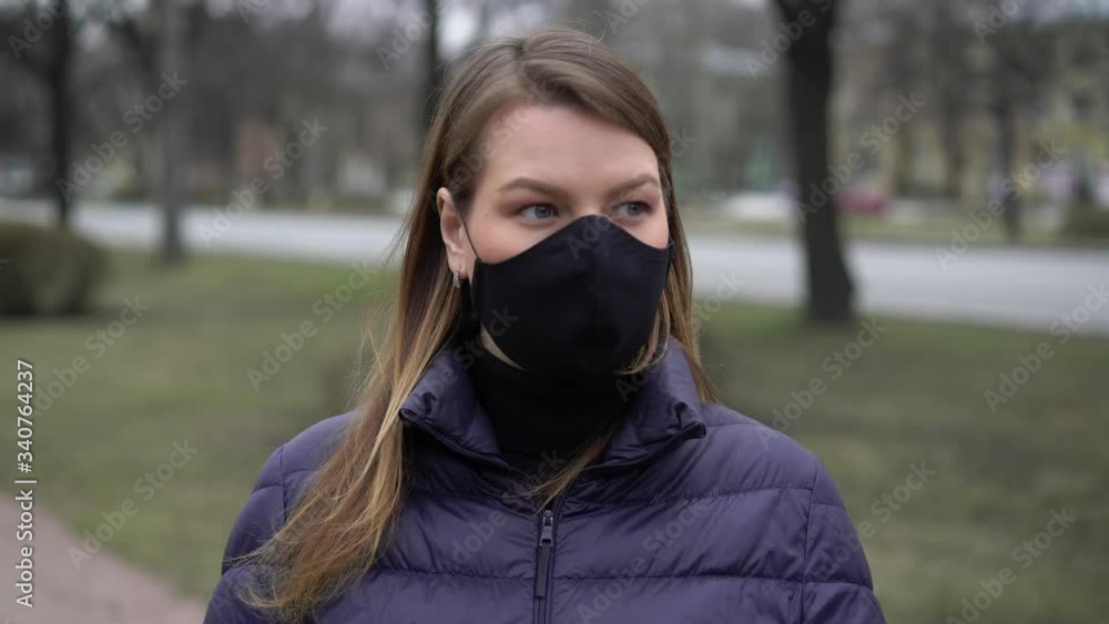 Woman put on face protective mask in a city. Epidemic covid-19 coronavirus Woman put on face protective mask in a city. Epidemic covid-19 coronavirus