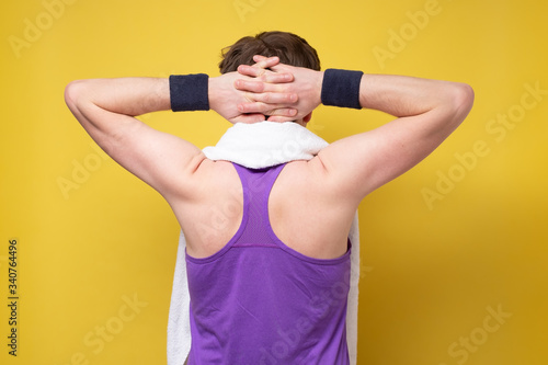 Caucasian sportive man resting after training. Rear view. photo