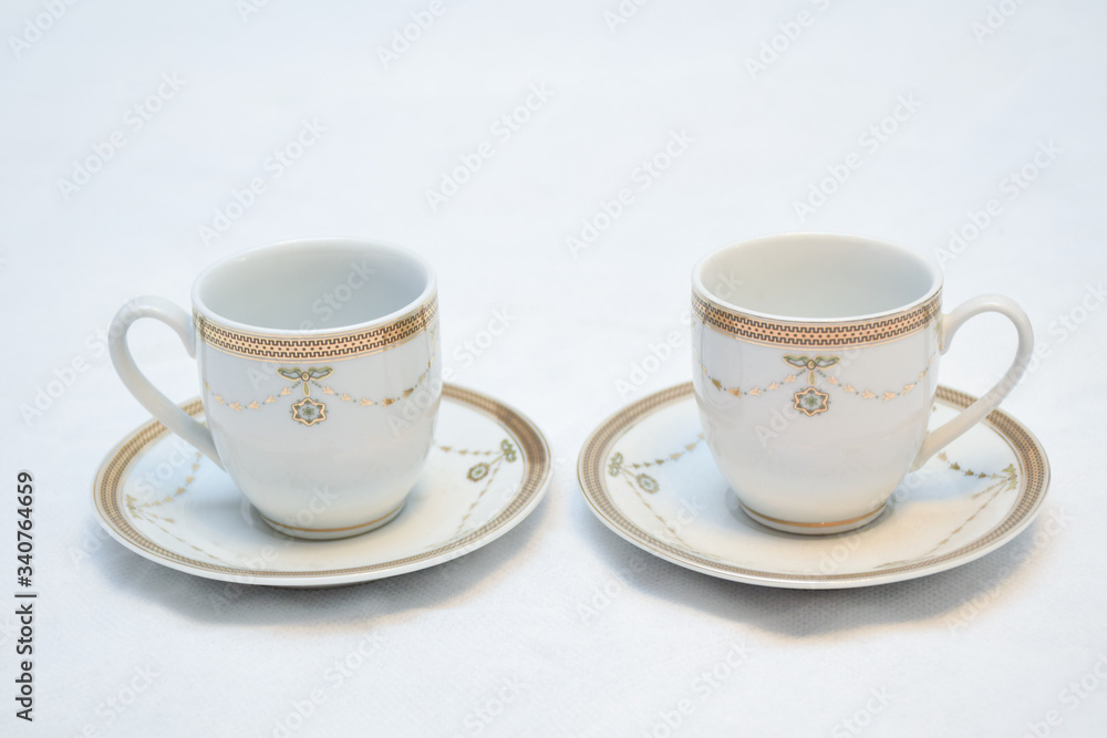 Mock up / design set of elegant and traditional teapot colorful white blue gold coffee cup & Tea cup on cup's plate beside the hot tea pot , design/ drink-ware isolated on white background Mock up / design set of elegant and traditional teapot colorful white blue gold coffee cup & Tea cup on cup's plate beside the hot tea pot , design/ drink-ware isolated on white background