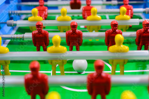 Futebol de mesa, pebolim de mesa. Vista de frente, bonecos de jogadores  de times vermelhos e amarelos posicionadas em uma mesa de  futebol. photo