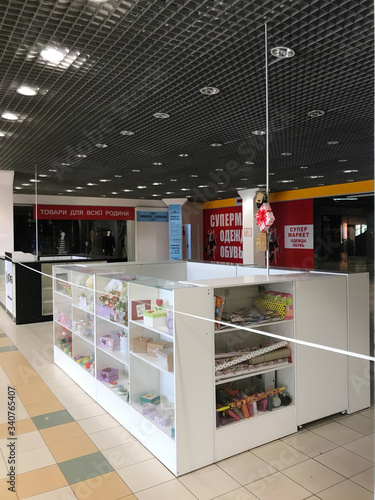 Kharkov, Ukraine, 11th april 2020: quarantined empty stores in the mall, tied with a white and red boundary tape in carantin time, wide shot © Анна Погорелая