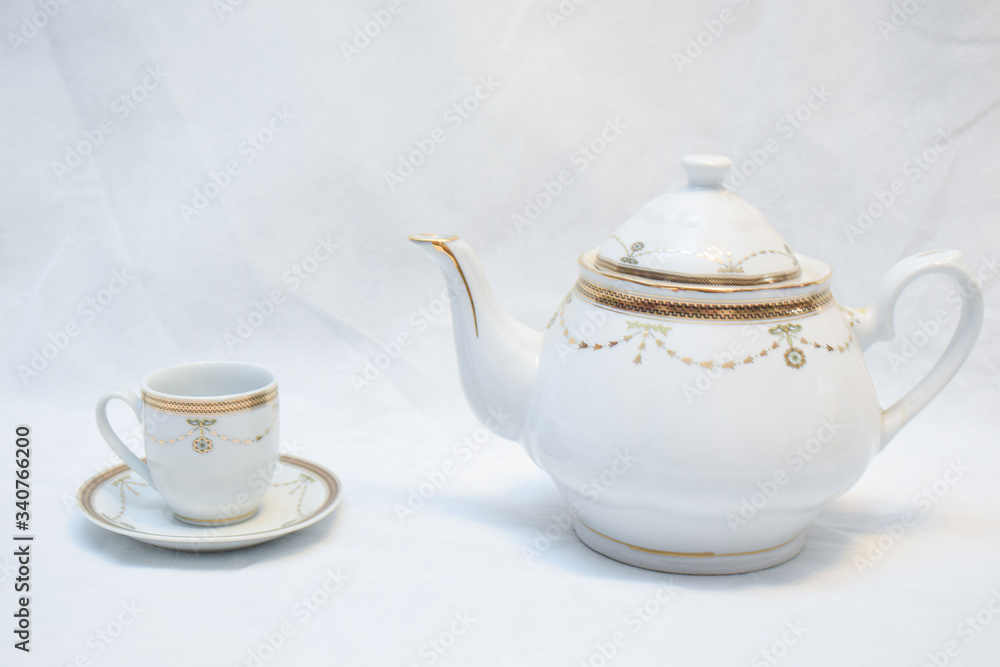 Mock up / design set of elegant and traditional teapot colorful white blue gold coffee cup & Tea cup on cup's plate beside the hot tea pot , design/ drink-ware isolated on white background Mock up / design set of elegant and traditional teapot colorful white blue gold coffee cup & Tea cup on cup's plate beside the hot tea pot , design/ drink-ware isolated on white background