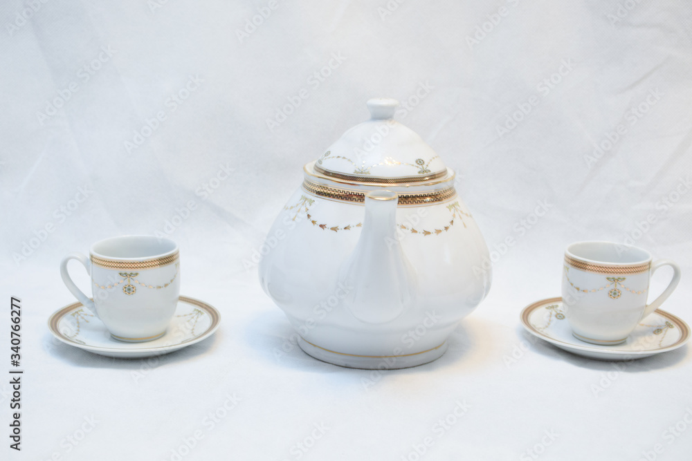 Mock up / design set of elegant and traditional teapot colorful white blue gold coffee cup & Tea cup on cup's plate beside the hot tea pot , design/ drink-ware isolated on white background Mock up / design set of elegant and traditional teapot colorful white blue gold coffee cup & Tea cup on cup's plate beside the hot tea pot , design/ drink-ware isolated on white background
