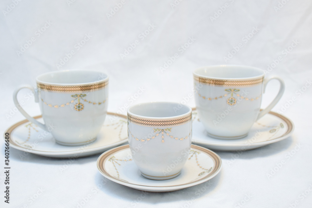 Mock up / design set of elegant and traditional teapot colorful white blue gold coffee cup & Tea cup on cup's plate beside the hot tea pot , design/ drink-ware isolated on white background Mock up / design set of elegant and traditional teapot colorful white blue gold coffee cup & Tea cup on cup's plate beside the hot tea pot , design/ drink-ware isolated on white background