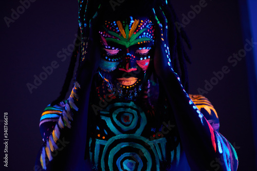 Obraz na plátně african man with fluorescent body art suffer from headache, hold head, stand with closed eyes