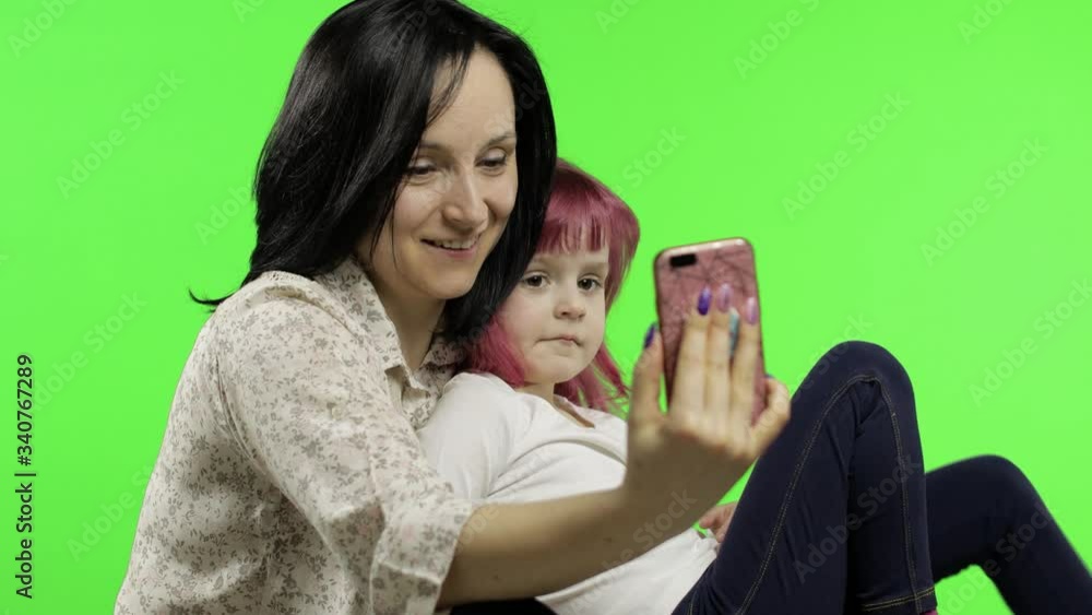 Mother, daughter holding, using smart phone talking on video call. Social media Mother, daughter holding, using smart phone talking on video call. Social media