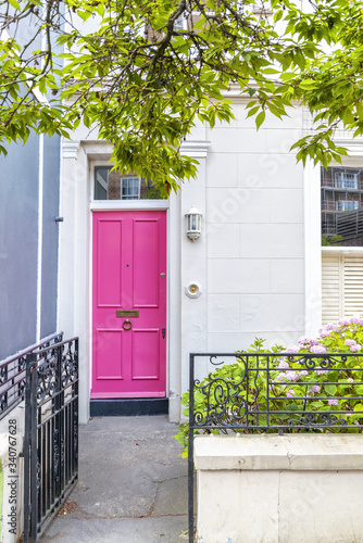 A vivid pink ornately decorated door and doorway in London, UK. Notting Hill area