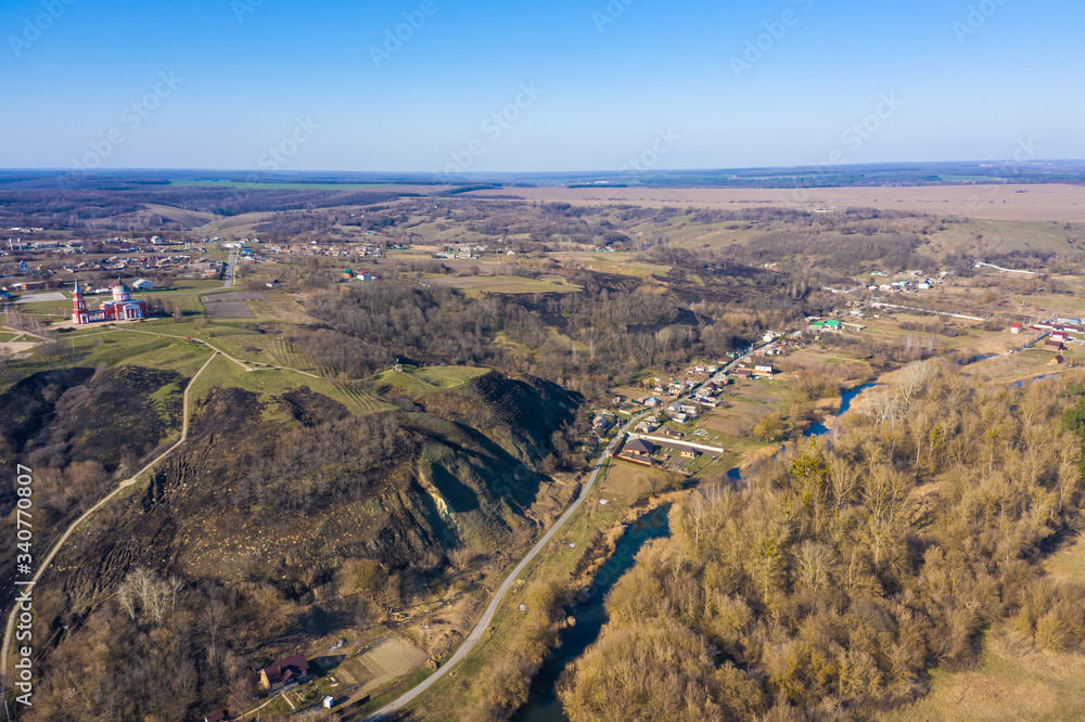 view from the drone to the hills, village with a Church on top, spring Sunny day, Central Russia