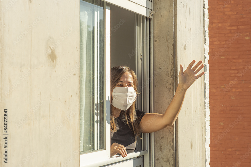 Woman in the windows during quarantine greeting a neighbor
