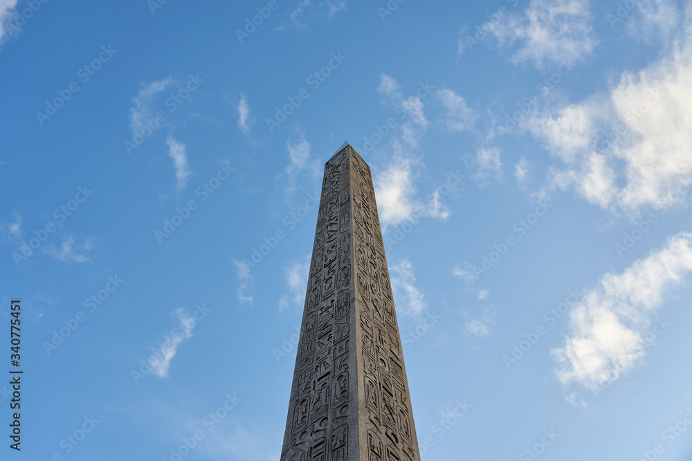 The Luxor Obelisk or Egyptian obelisk on the Place de la Concorde against a blue sky in Paris, France. 