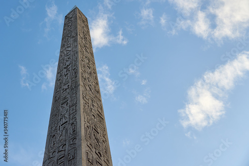 Fotografia The Luxor Obelisk or Egyptian obelisk on the Place de la Concorde against a blue sky in Paris, France