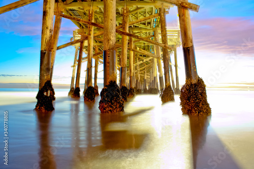 sunset on the beach under the pier