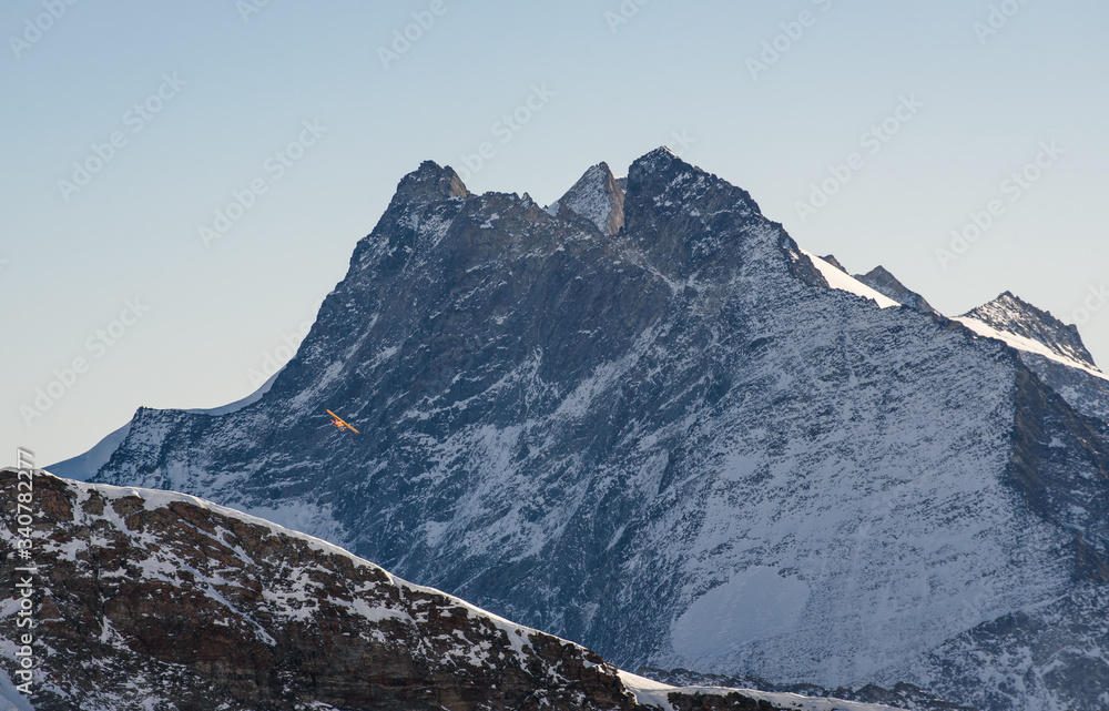 Yellow plane flying above the Jungfraujoch