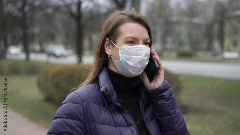 Woman in face protective mask in a city with mobile phone. covid-19 coronavirus Woman in face protective mask in a city with mobile phone. covid-19 coronavirus
