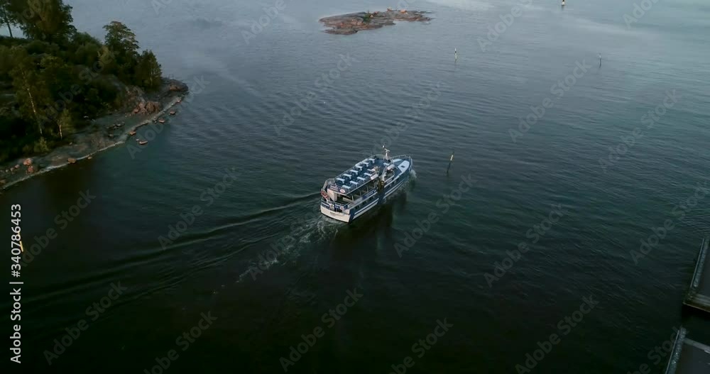 Aerial, tracking, drone shot of following a ferry moving towards Suomenlinna island, on the coast of Helsinki, sunset. in Helsingfors, Finland Aerial, tracking, drone shot of following a ferry moving towards Suomenlinna island, on the coast of Helsinki, sunset. in Helsingfors, Finland